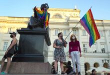 Ein LGBT-Aktivist mit einer Regenbogenfahne steht am 7. August 2020 auf dem Kopernikus-Denkmal in Warschau, Polen. Die polnische Polizei verhaftete am Freitag einen Aktivisten für die Rechte von Homosexuellen im Zentrum von Warschau und setzte einen Gerichtsbeschluss für eine zweimonatige Sicherungsverwahrung um, der wütend wurde Szenen, als Dutzende protestierten. Die Aktivistin, die vor Gericht offiziell als Mikhail Sz bezeichnet wurde, sich aber als Frau mit dem Namen Margo identifiziert, wird verdächtigt, im Juni in Warschau einen Lieferwagen mit homophoben Parolen beschädigt zu haben. (Foto: JANEK SKARZYNSKI/AFP)