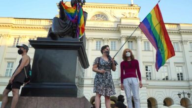Ein LGBT-Aktivist mit einer Regenbogenfahne steht am 7. August 2020 auf dem Kopernikus-Denkmal in Warschau, Polen. Die polnische Polizei verhaftete am Freitag einen Aktivisten für die Rechte von Homosexuellen im Zentrum von Warschau und setzte einen Gerichtsbeschluss für eine zweimonatige Sicherungsverwahrung um, der wütend wurde Szenen, als Dutzende protestierten. Die Aktivistin, die vor Gericht offiziell als Mikhail Sz bezeichnet wurde, sich aber als Frau mit dem Namen Margo identifiziert, wird verdächtigt, im Juni in Warschau einen Lieferwagen mit homophoben Parolen beschädigt zu haben. (Foto: JANEK SKARZYNSKI/AFP)