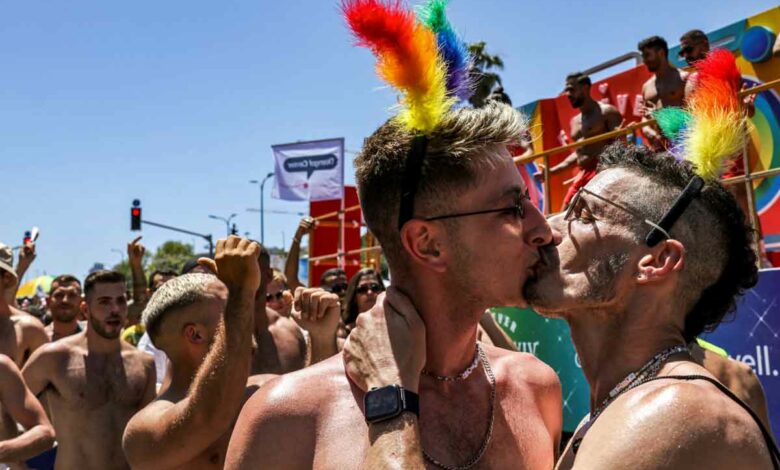 Participants kiss during the annual Pride Parade in Israel's Mediterranean coastal city of Tel Aviv on June 10, 2022. (Photo by RONALDO SCHEMIDT / AFP)