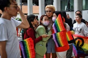 LGBTQIA+ activists and supporters celebrate with Move Forward Party members after the initial passing of the Marriage Equality Bill outside parliament in Bangkok on June 15, 2022. (Photo by Lillian SUWANRUMPHA / AFP)