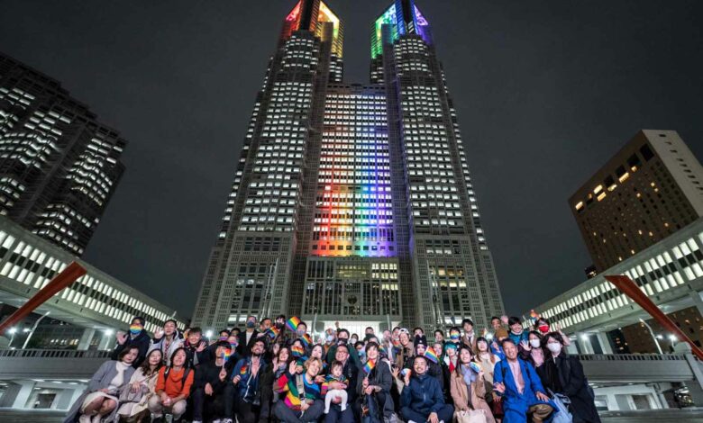 Menschen vor dem mit Regenbogenlichtern beleuchteten Gebäude der Tokyo Metropolitan Government im Tokioter Stadtteil Shinjuku. Tokio begann am 1. November 2022 mit der Ausstellung von Partnerschaftsurkunden für gleichgeschlechtliche Paare, die in der Hauptstadt leben und arbeiten. (Foto von Yuichi YAMAZAKI / AFP)