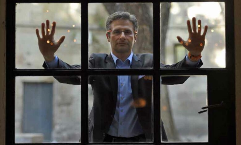 Der frühere katholische Priester Krzysztof Charamsa hinter einem Fenster währendes AFP-Interviews am 11. November 2015 in Barcelona (Foto: Lluis Gene/AFP)